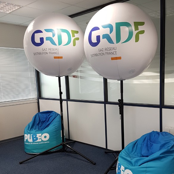 Des ballons à l'air posé sur un mats télécopique